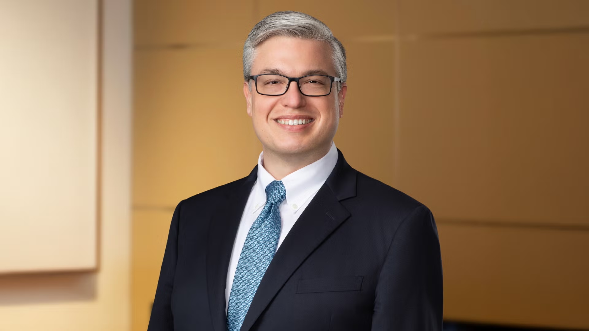 A smiling man in suit and tie, portrait of Joe Gratz