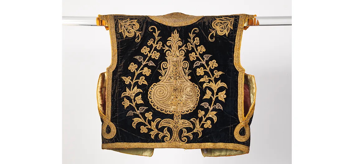Image of a black velvet vest with ornate gold embroidery