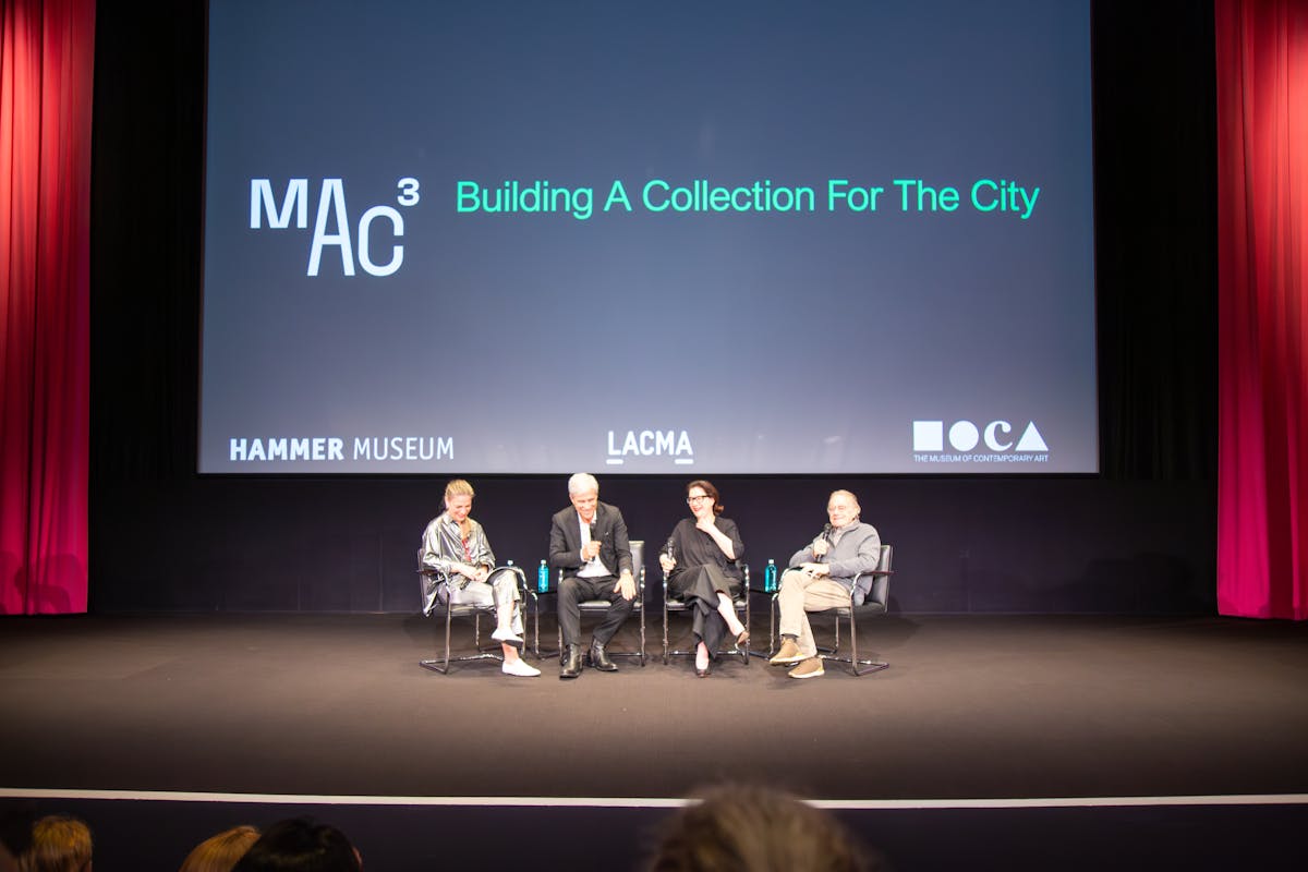Four arts leaders sit in a row on a stage, talking about the MAC 3 initiative