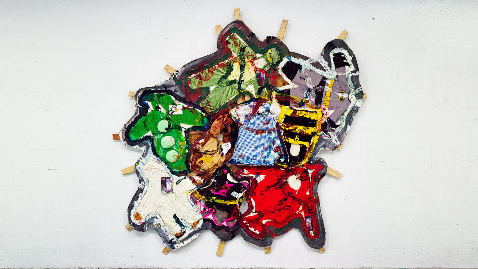 Image of a sculptural artwork using colorful textiles and other material objects.