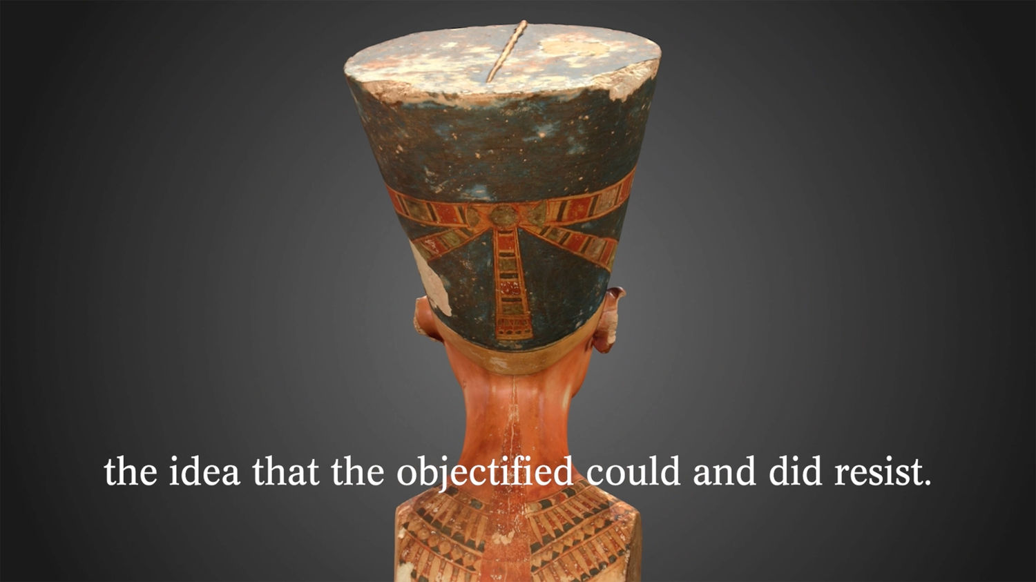 Screen shot from a short film titled Specular Fiction. In the shot is an egyptian statue from behind, with the words "the idea that the objectified could and did resist" on the screen