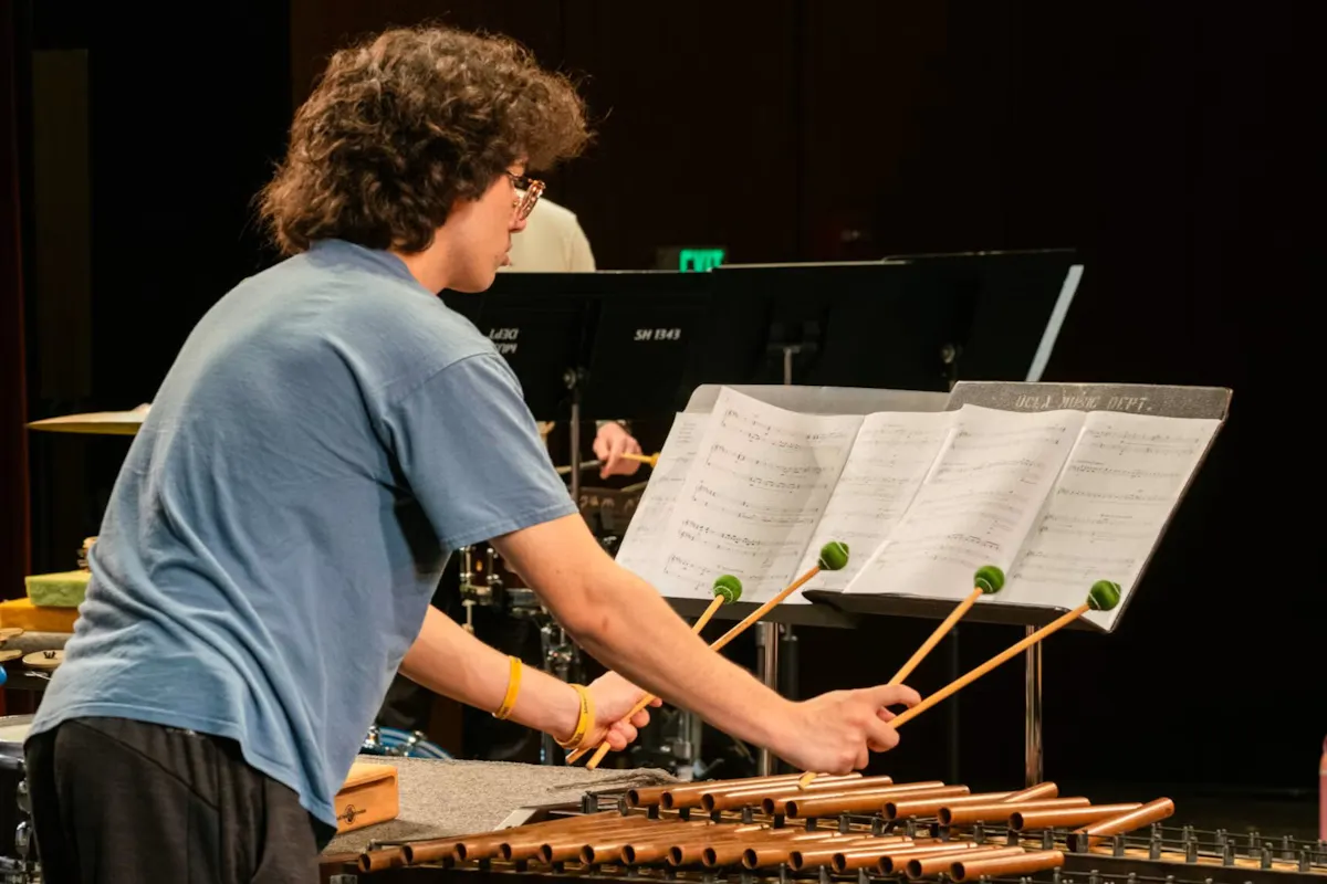 A percussionist holding four mallets, playing his instrument.