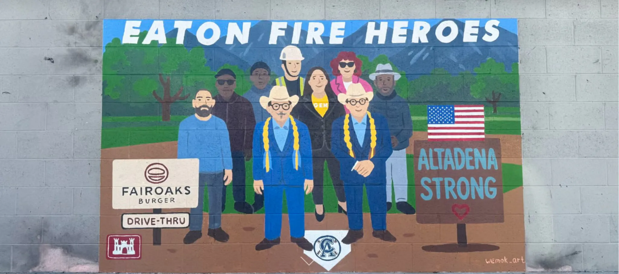 Painting mural of people with words "Eaton fire heroes" on top and a sign that says "Altadena strong".