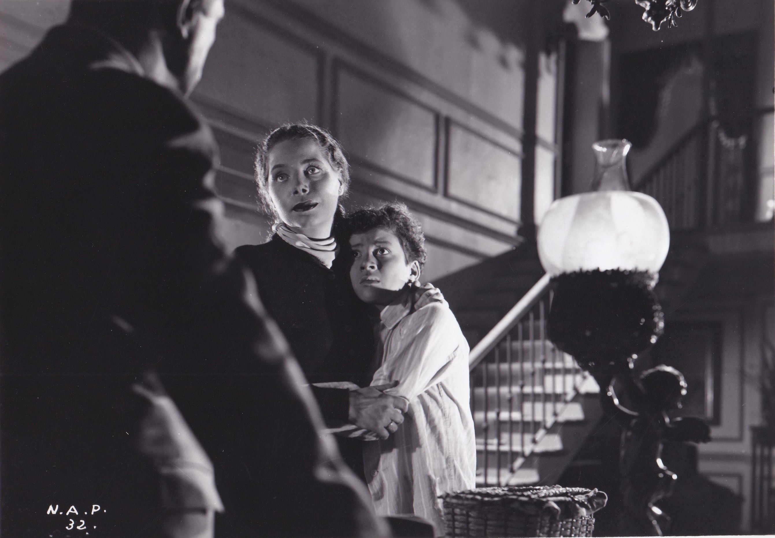 woman on staircase holding frightened looking boy