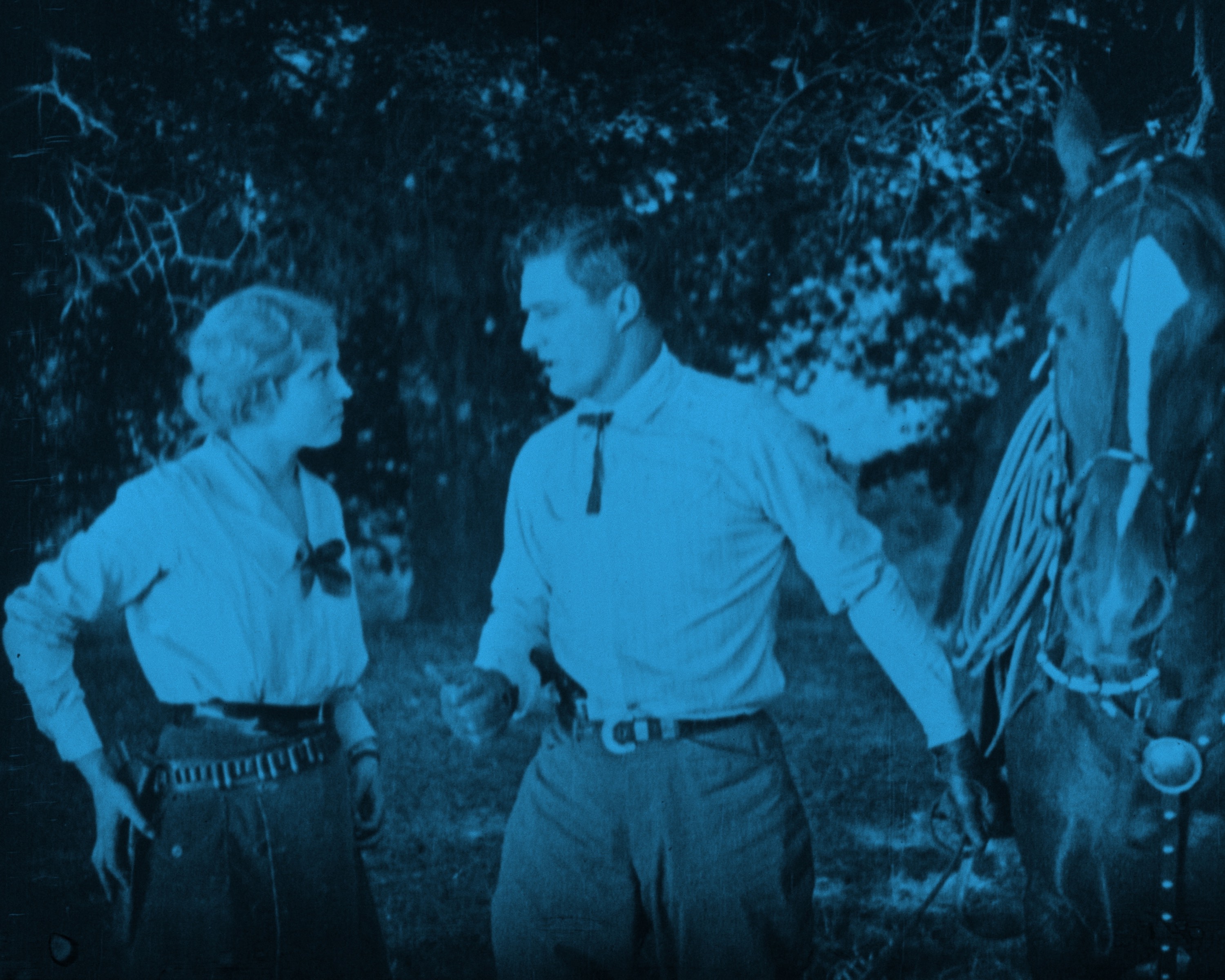 Woman with gun on hip in holster talking to man with a horse