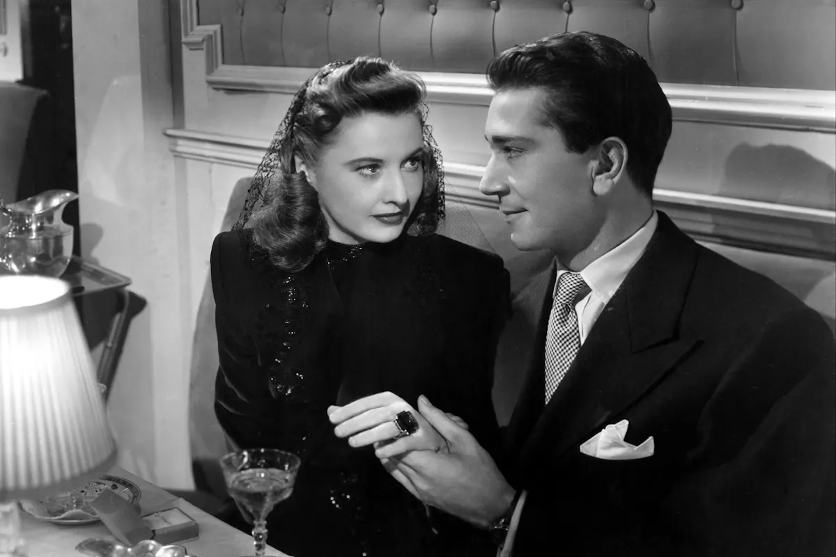 Man holding woman's hand while they're seated at a restaurant table