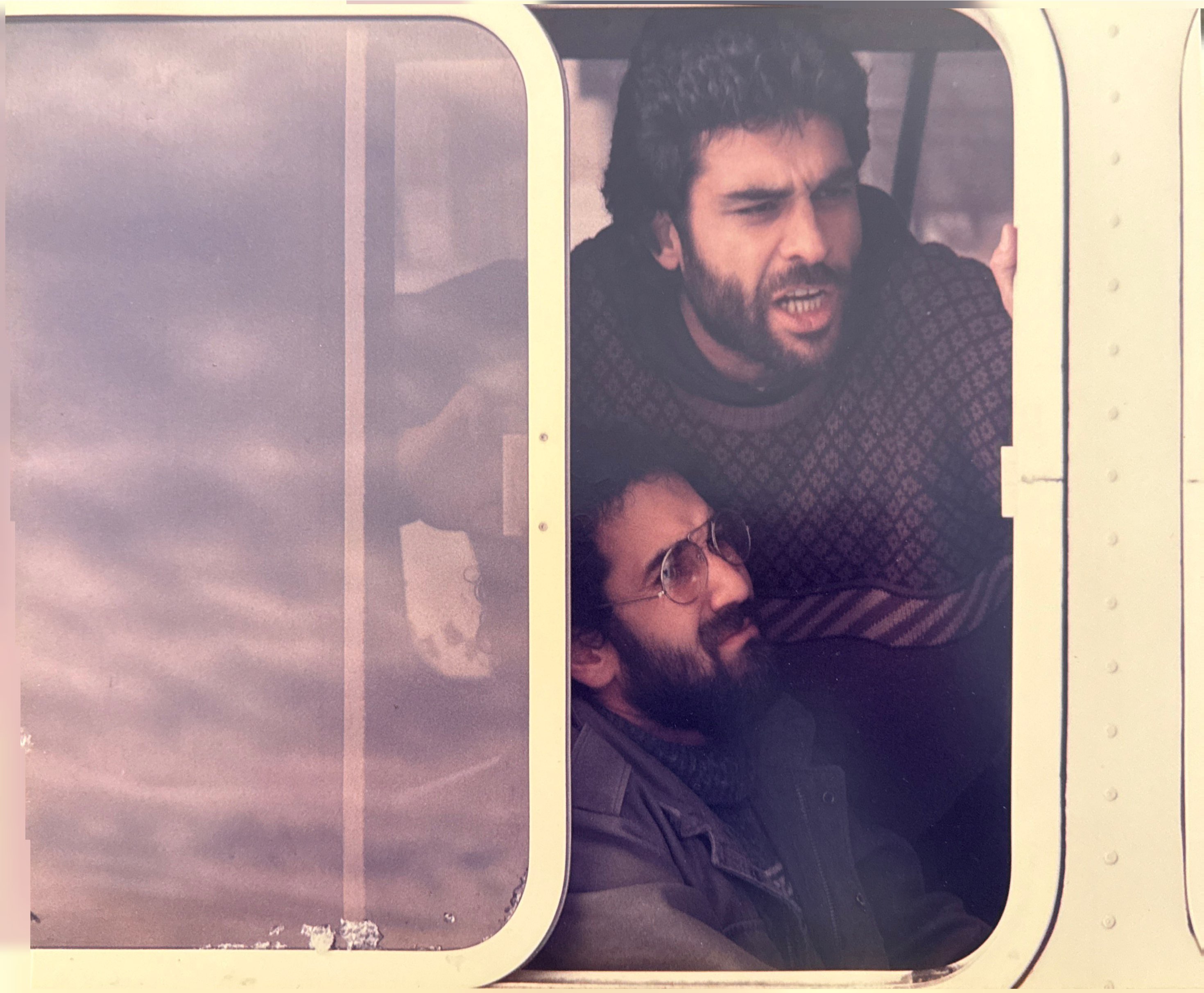 Two men showing distress in front of a sliding glass