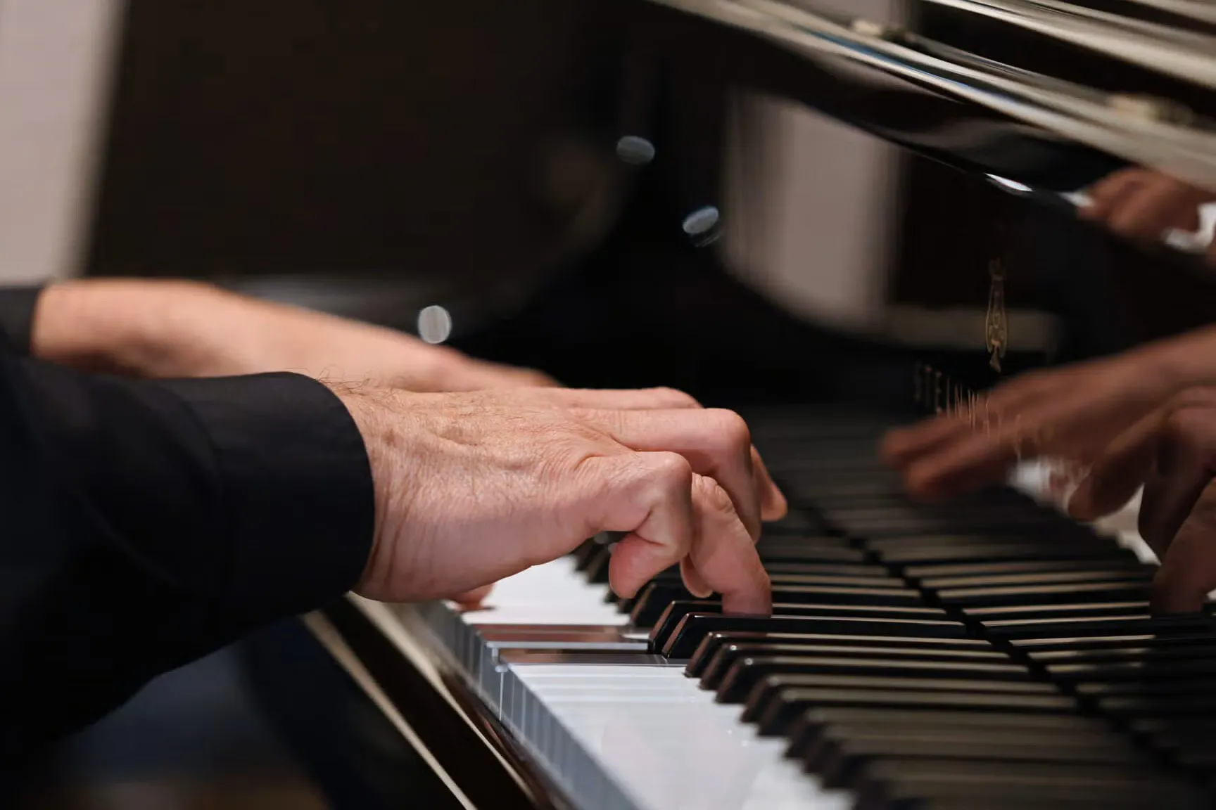 Hands on a piano, playing.