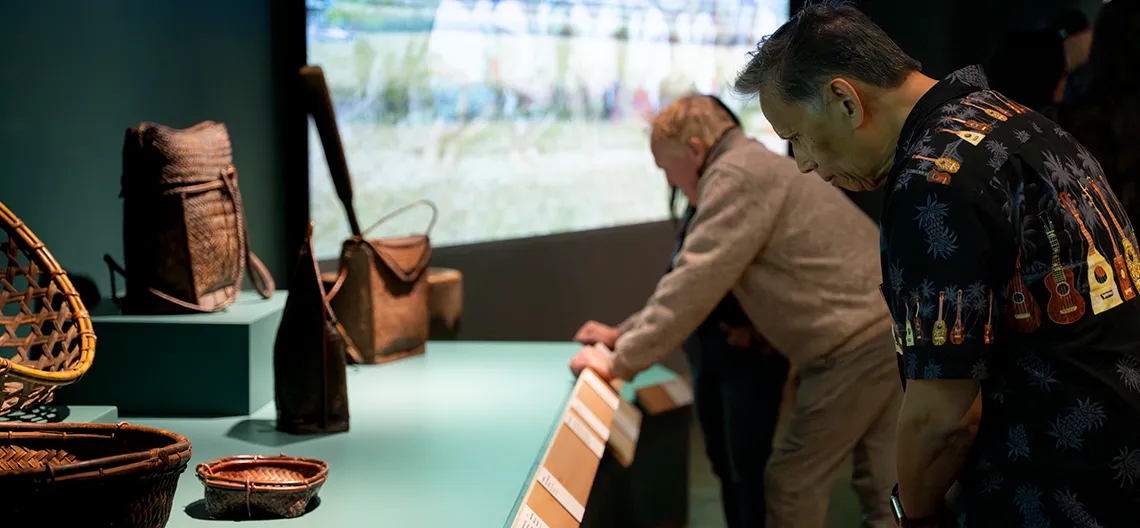 Visitors to Fowler Museum view hand woven baskets