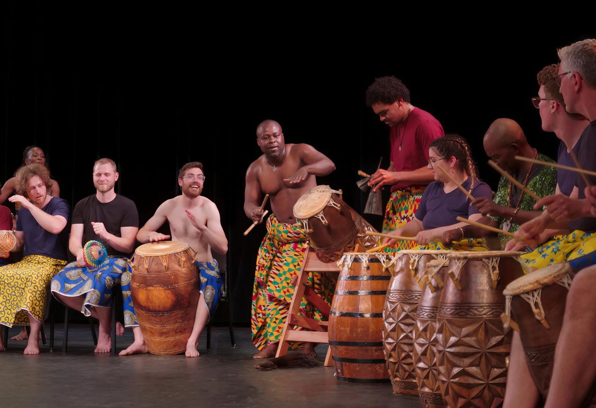 A group of performers play African drums