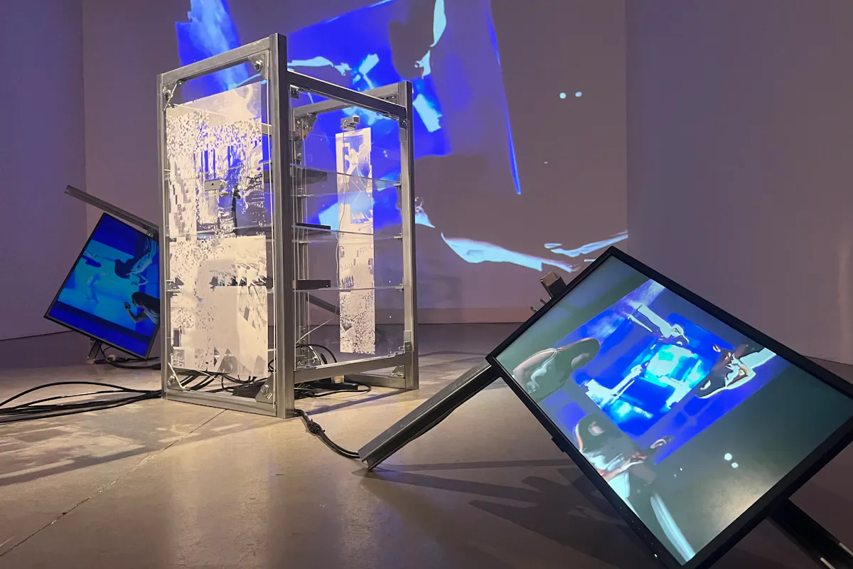 Multiple video screens of dancers awash in blue light