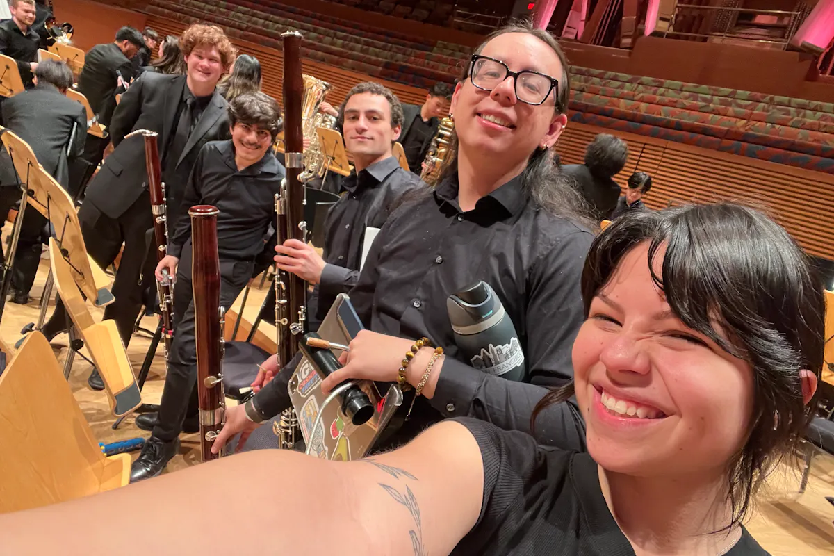 A group of bassoon players pose together after a performance