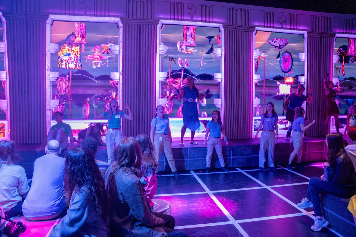 Large LED screens awash in purple lighting on a stage portray a digital world