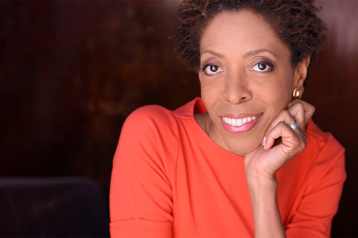 A photo of Diane White-Clayton, smiling, with a reddish shirt.