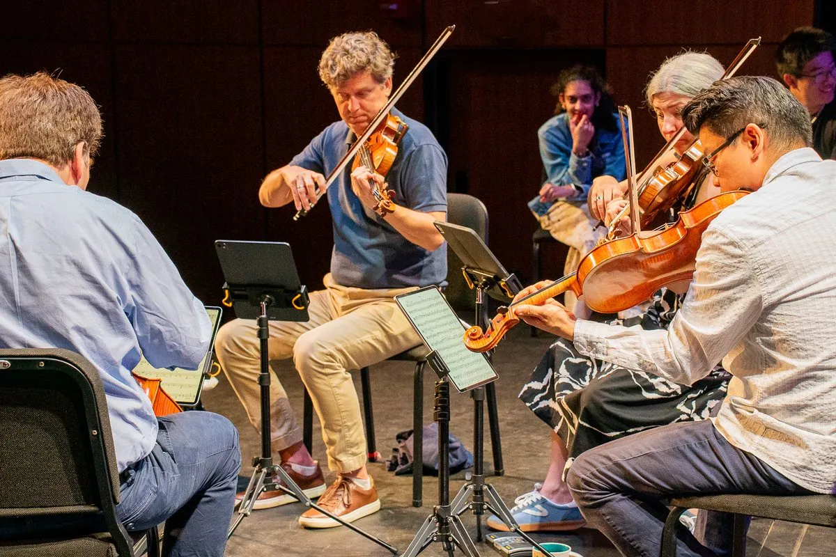 A group of string performers on stage