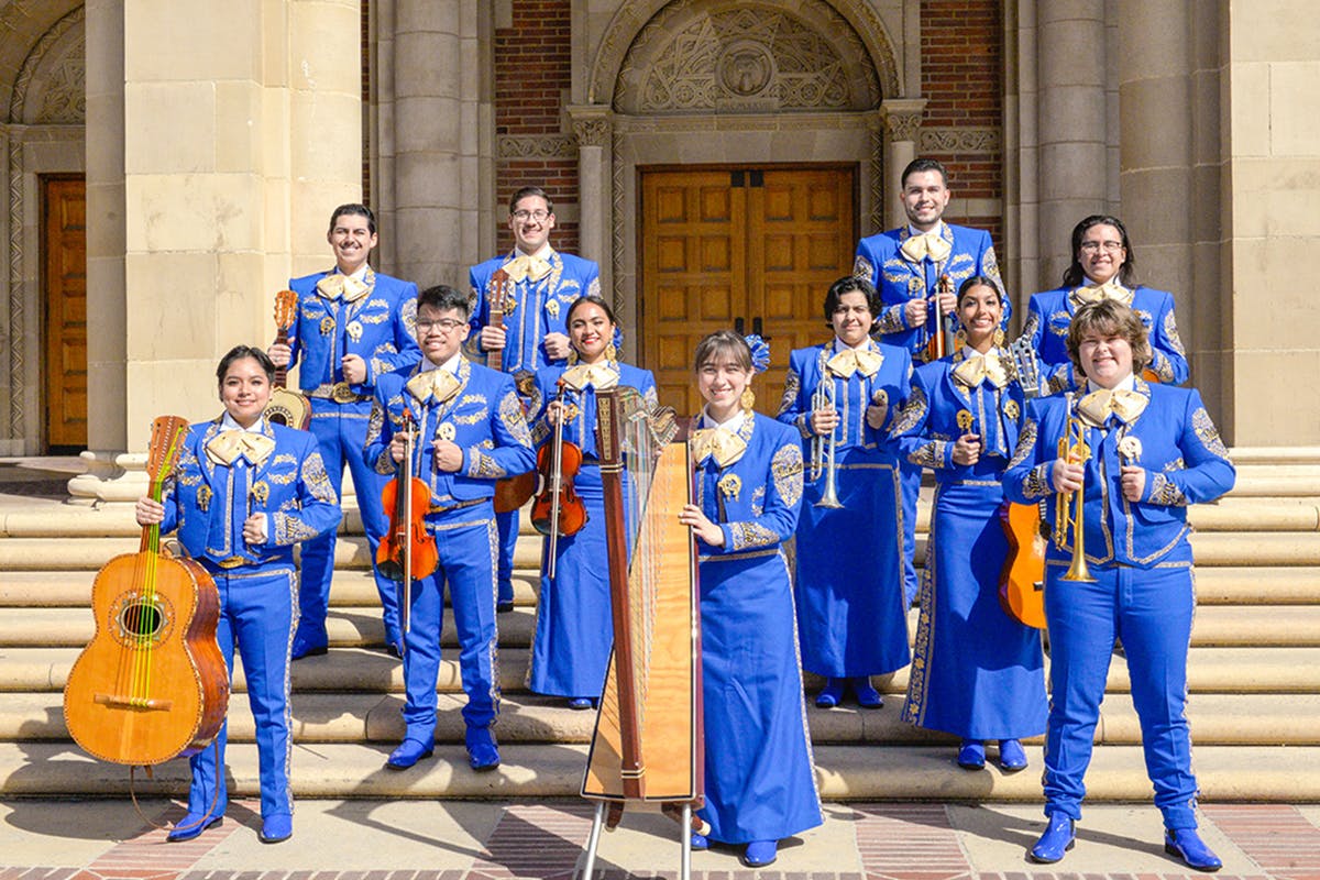 Mariachi band poses in bright blue costumes