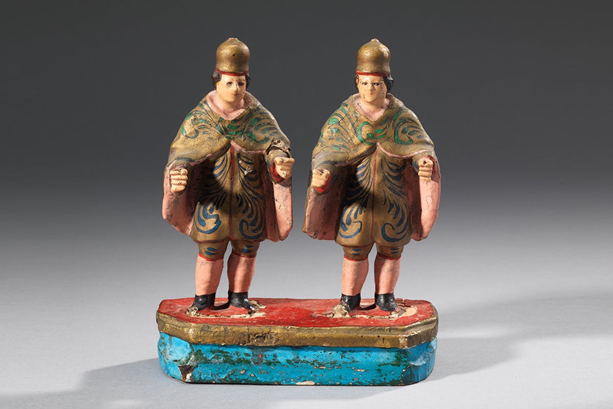 Statue of twin figures in European renaissance costumes.