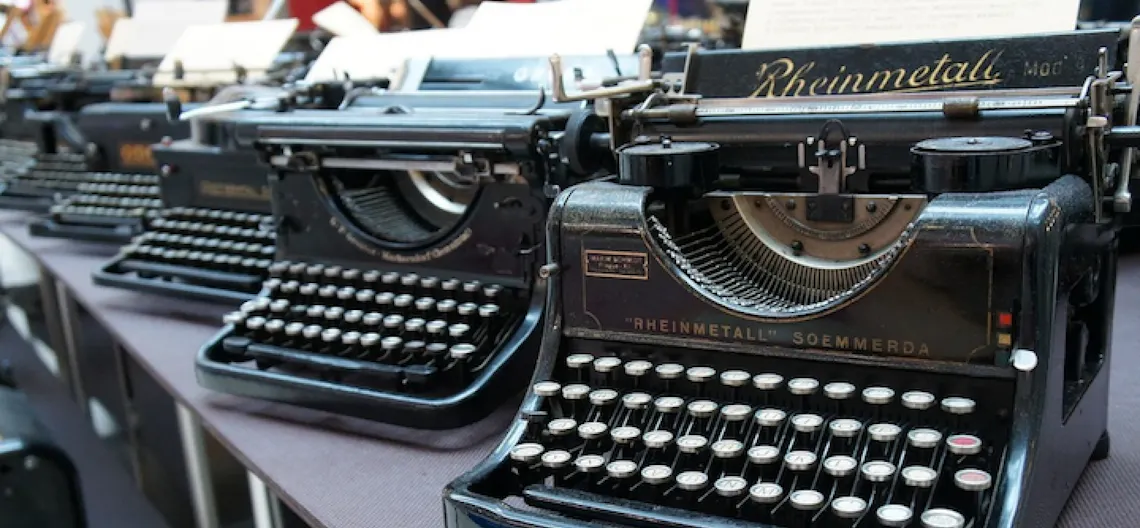 Several vintage typewriters on a table