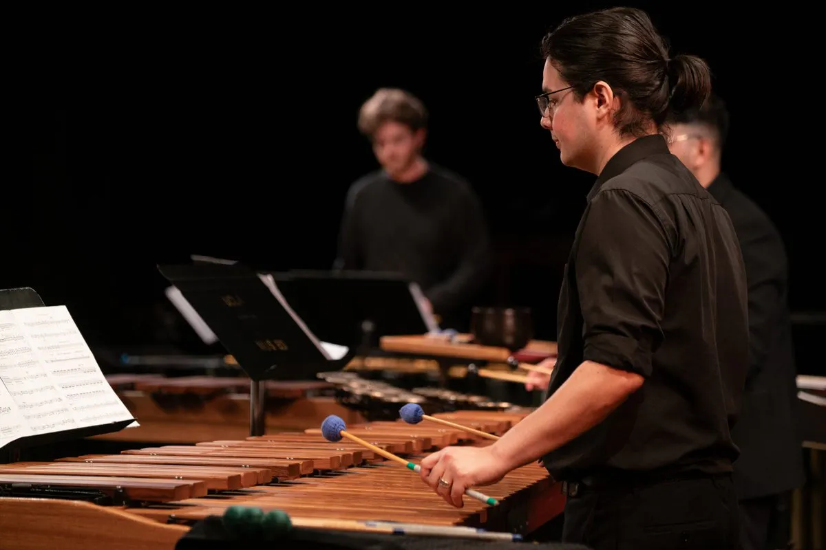 A performer playing the marimba with an orchestra