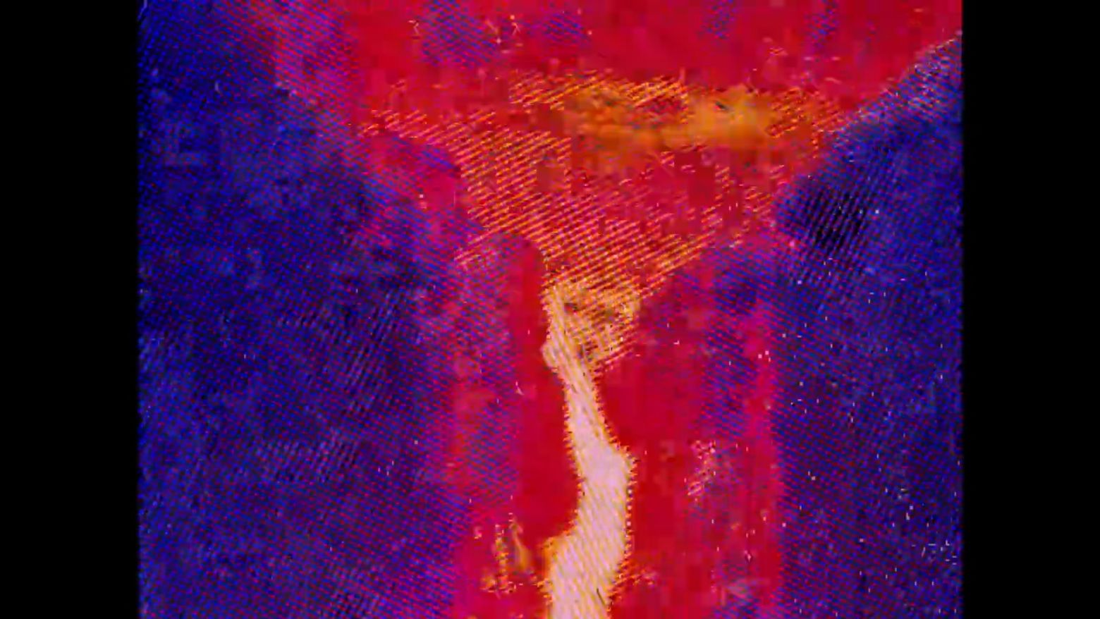 Detail view of a shot from a 35 mm film, an orange and red blurry image jets vertically against a purple background