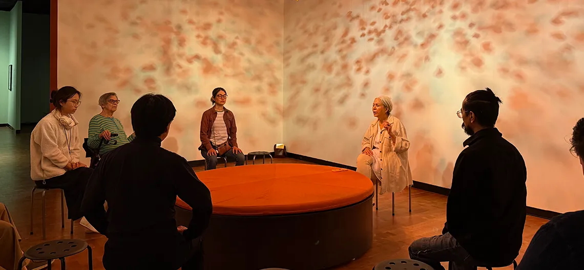 People sit together in the Fowler museum and meditate with a teacher