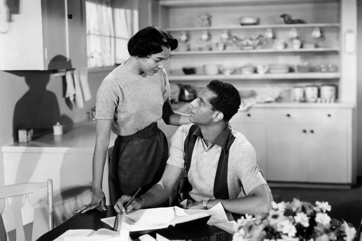 a man and a woman in the kitchen of a house looking at each other
