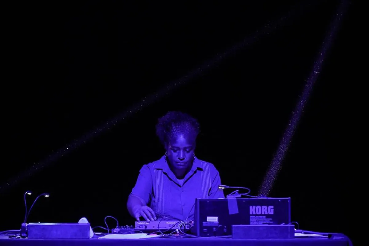 A performer works with electronics onstage