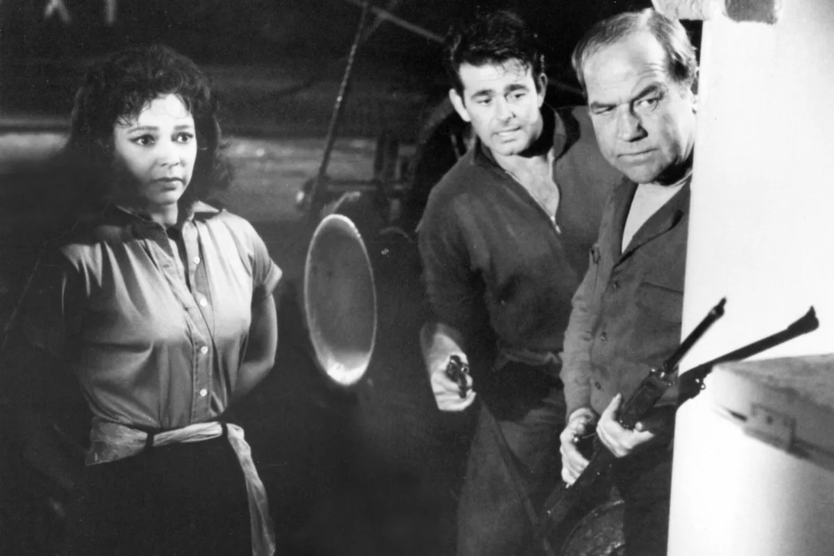 2 men and a woman looking defensive. the men are holding guns