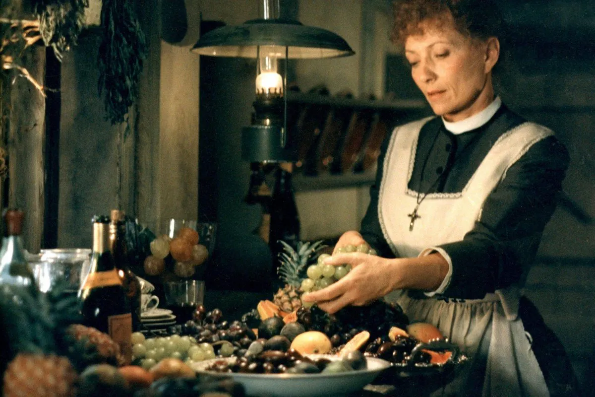 a woman in a kitchen touching a plate of fruit