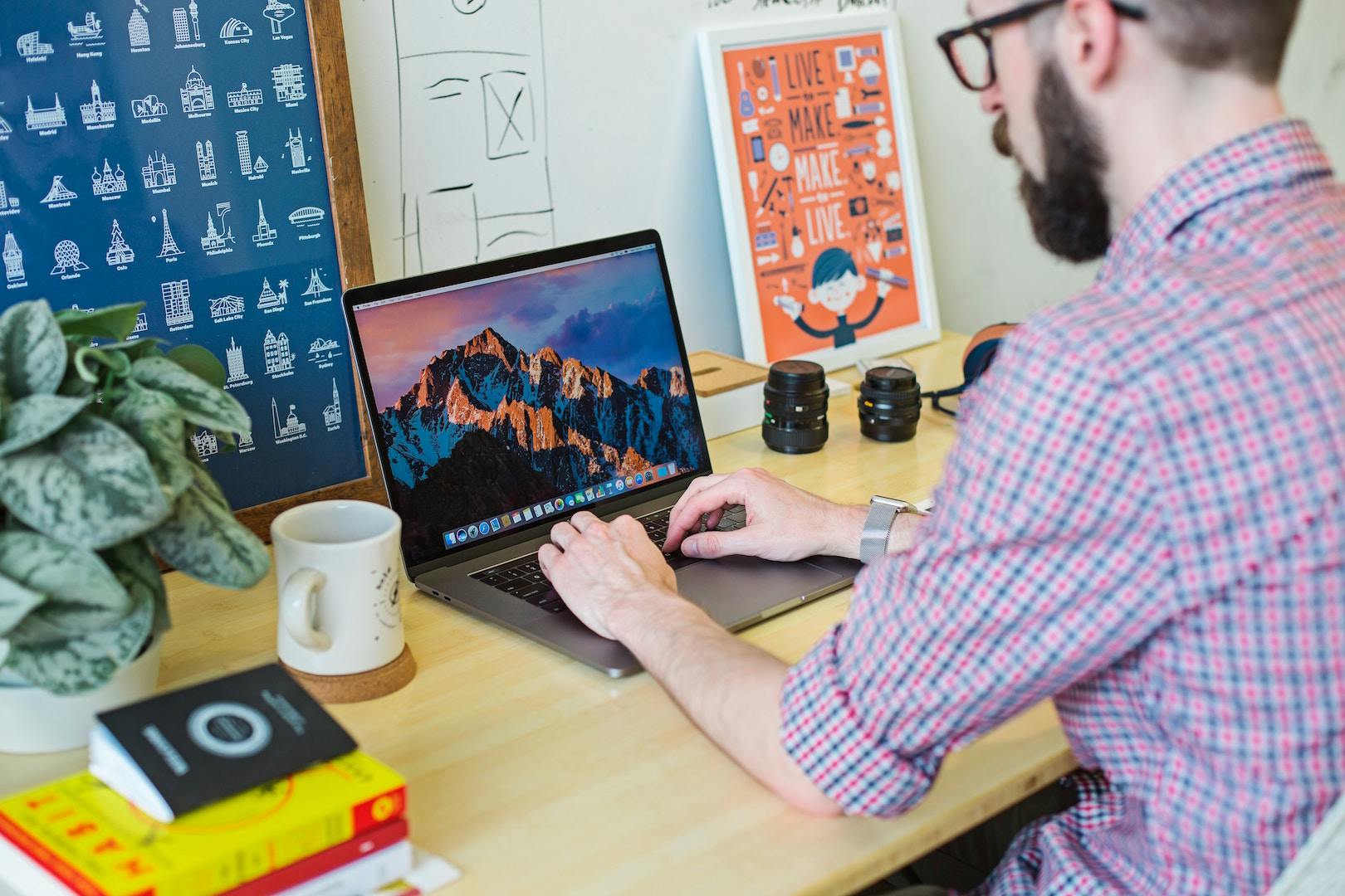 Man sitting at a desk typing on a laptop