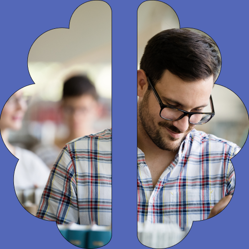 Man wearing glasses and a checkered shirt smiling in the office