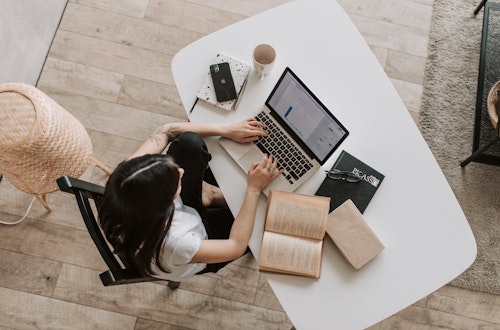 Woman working on her laptop at a desk at home, indicating engagement