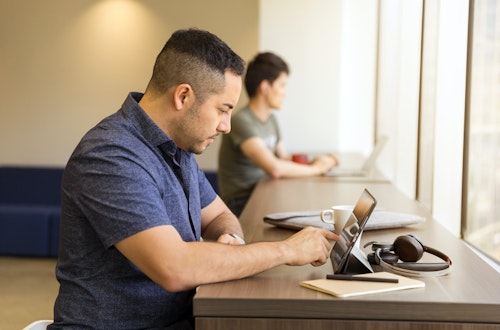 Man typing on a tabled in a cafe