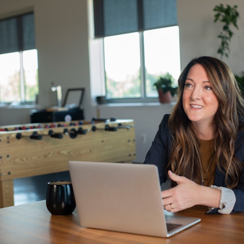 Woman sitting at her laptop drining a cup of coffee