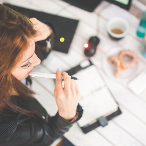 Woman sitting at a desk writing in a notepad