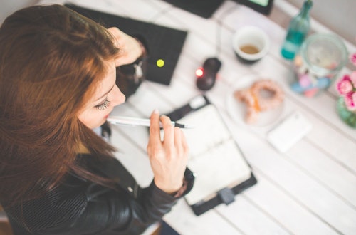 Woman sitting at a desk writing in a notepad