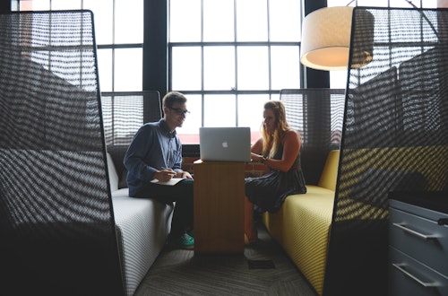 Two people working together on a laptop, while one takes notes, symbolising the skills gap