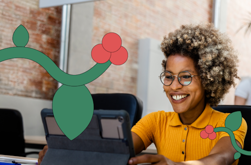 Woman sitting at her desk smiling at an iPad