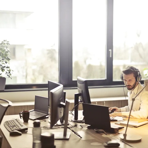 Man speaking to customers via a headset and building rapport