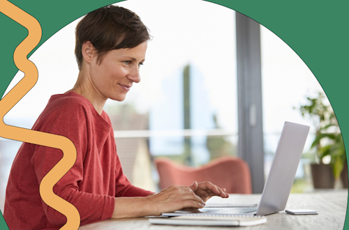 Woman sitting in front of a laptop smiling