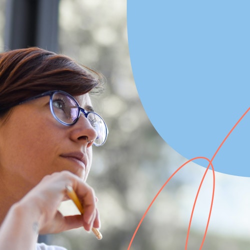 Woman wearing glasses and holding a pencil staring out the window