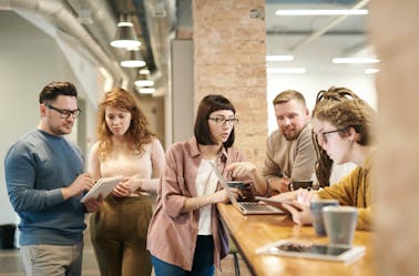 Group of people talking and looking at their tablets in an office