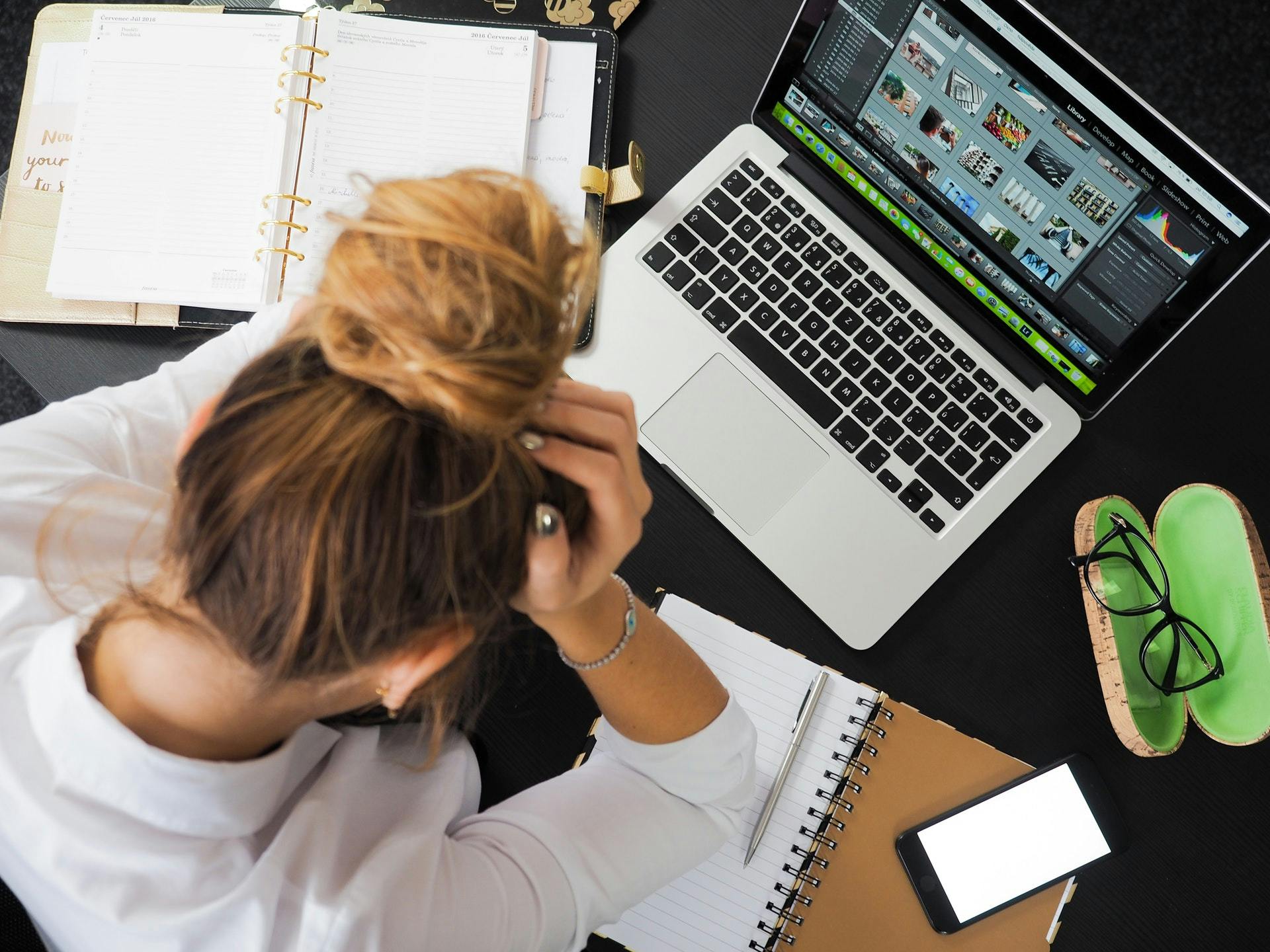 Lady with her head in her hands looking stressed at work 