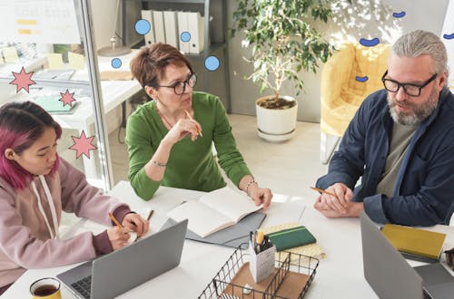 Three people sitting at a table having a meeting