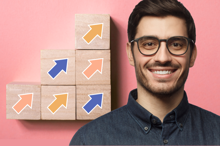 Man smiling next to building blocks pointing upwards