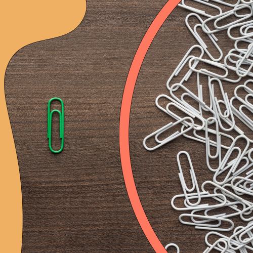 Collection of paperclips and one green single paperclip