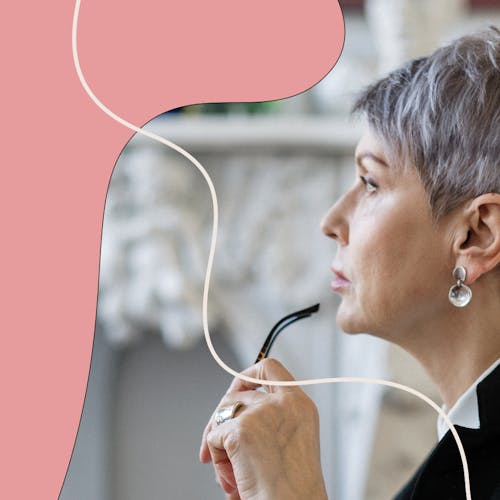 Woman holding a pair of glasses to her lip and staring out the window