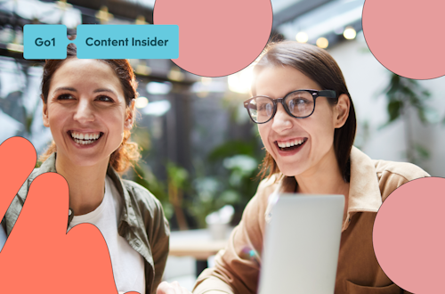 Two women working collaboratively with a laptop and big smiles