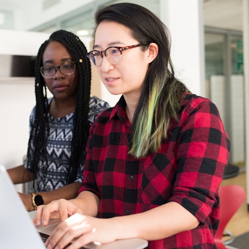 Woman in red and black checkered shirt working on her computer