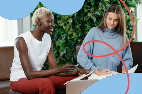 Two women having a conversation and taking notes in the workplace